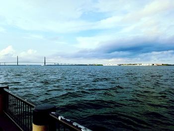 Pier on sea against cloudy sky