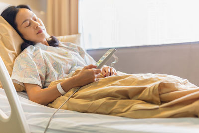 Woman patient hand using remote control for adjust level bed in hospital