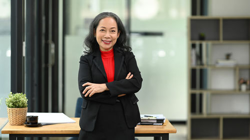 Portrait of young businesswoman standing in library