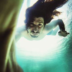 Portrait of young woman swimming in sea