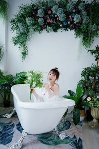 Portrait of young woman in bathtub at home