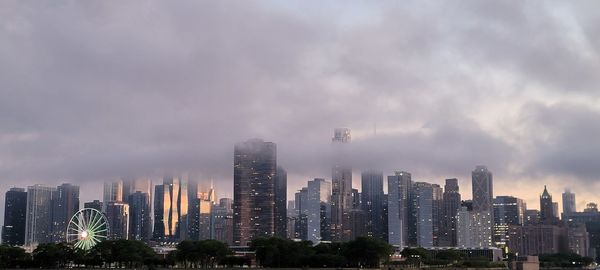 Buildings in city against cloudy sky