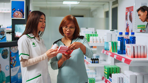 Portrait of smiling female friends working in laboratory