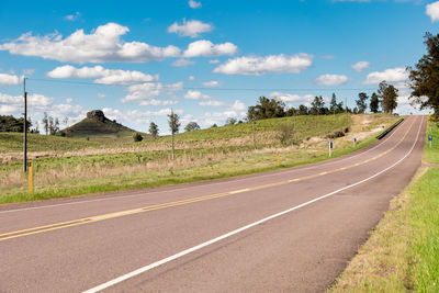 A road without any cars and some hills on the background in uruguay, next to tacuarembó. 