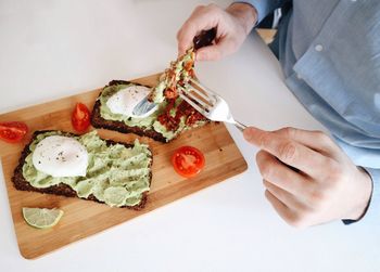 Midsection of man having breakfast at table