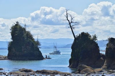 View of sailboats in sea against cloudy sky