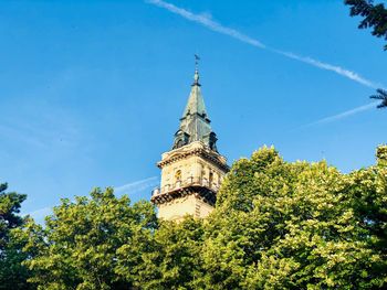 Low angle view of trees and building against sky