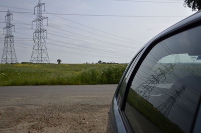 Electricity pylon on field against clear sky