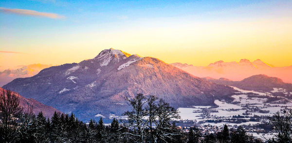 Scenic view of snowcapped mountains against sky during sunset