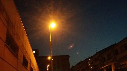 Low angle view of illuminated city against sky at night