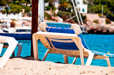 Empty chairs by swimming pool at beach