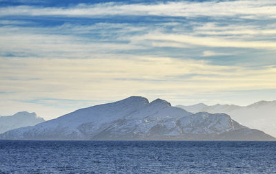 Scenic view of sea and mountains against sky during sunset