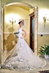 Portrait of smiling young bride with bouquet at home