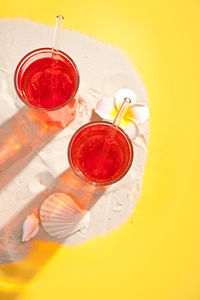 Directly above shot of drinks over yellow background