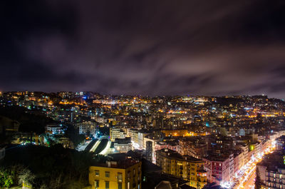 Illuminated cityscape against sky at night