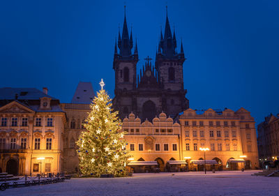Christmas tree and illuminated old town square in prague, czech rpublic, covered by fresh snow