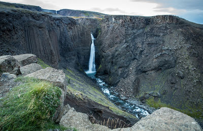 Scenic view of waterfall in mountains