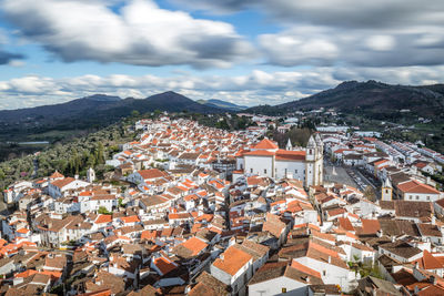 High angle view of houses in town against sky