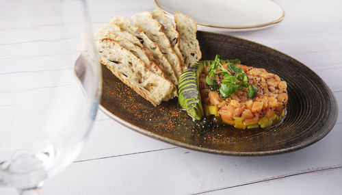 Gourmet fish tartar raw from tuna fillet with hashed avocado, selective focus