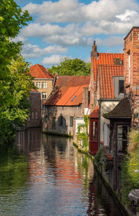 Canal amidst buildings in town against sky