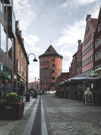 Street amidst buildings against sky in city