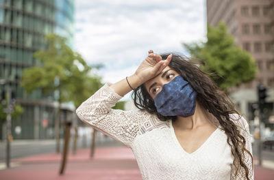 Close-up of woman wearing flu mask looking away standing outdoors