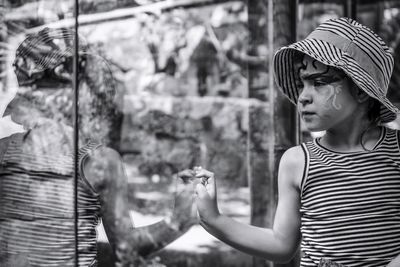 Girl standing by glass