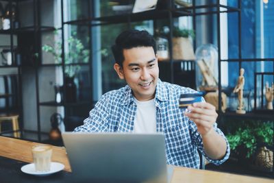 Young man using mobile phone in cafe