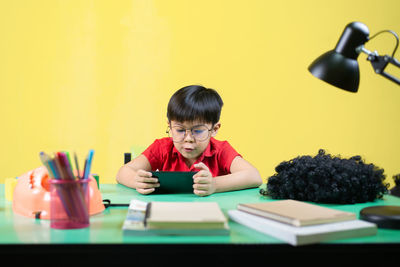 Portrait of boy sitting on table