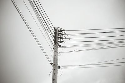 Low angle view of electricity pylon against clear sky