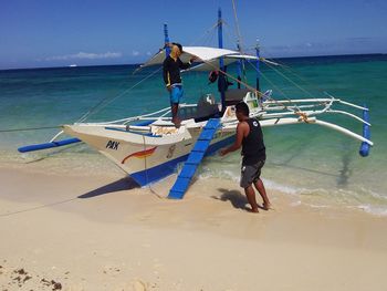 People standing on beach against sky