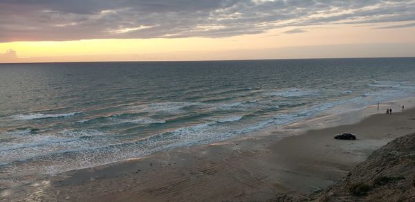 Scenic view of beach against sky during sunset