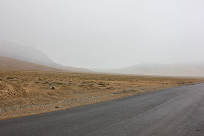 Scenic view of road by land against sky