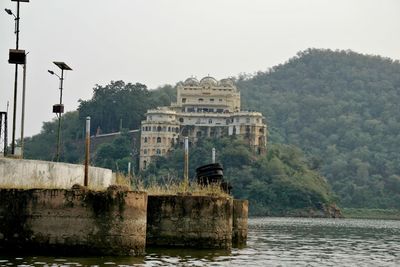 Built structure by river against clear sky