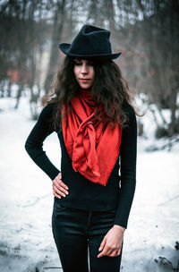 Woman wearing hat standing on snow covered land