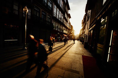 Blurred image of people walking on street amidst buildings