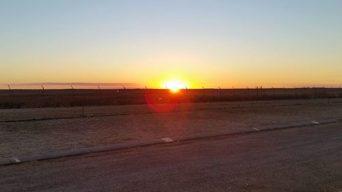 Scenic view of field against clear sky during sunset