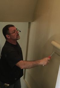 Side view of man holding cigarette against wall