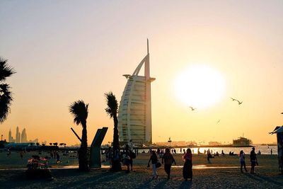 People in sea at sunset