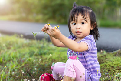 Portrait of cute baby girl plucking flowers