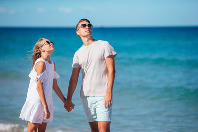 Portrait of smiling friends standing at beach