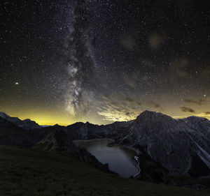 Scenic view of lake by mountains against sky during sunset