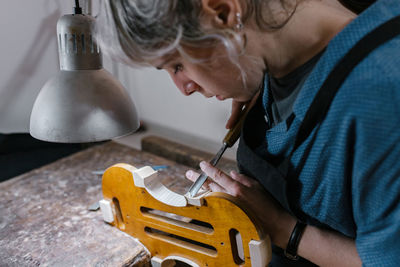 Midsection of man working on wood