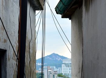 Bridge by buildings in city against sky