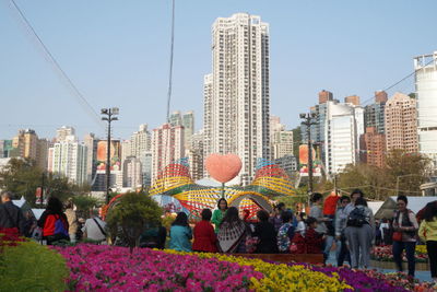 Panoramic view of people in city against clear sky