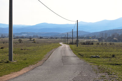 Road amidst field against sky