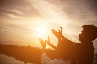 Silhouette people against sky during sunset