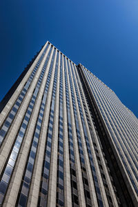 Low angle view of modern building against clear blue sky