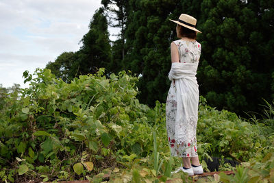 Woman standing by tree on field