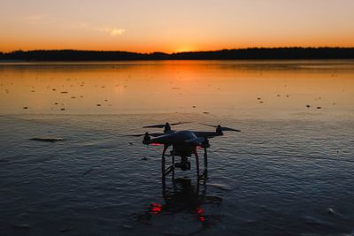 View of drone on lake during sunset